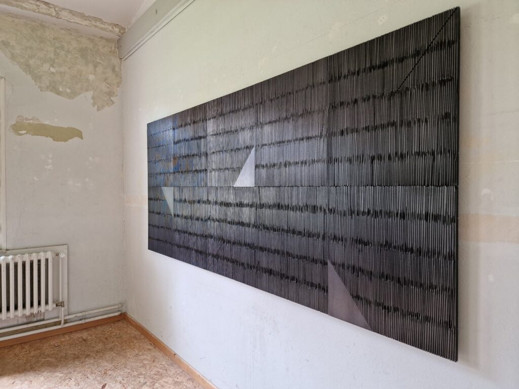 schwarze Reliefplatten aus Holz an der Wand